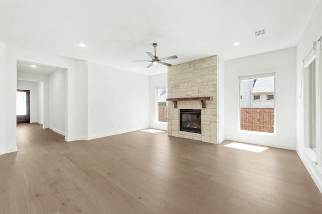 unfurnished living room with wood-type flooring, a fireplace, and ceiling fan