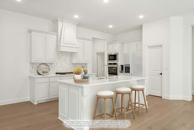 kitchen with plenty of natural light, sink, an island with sink, white cabinets, and stainless steel dishwasher