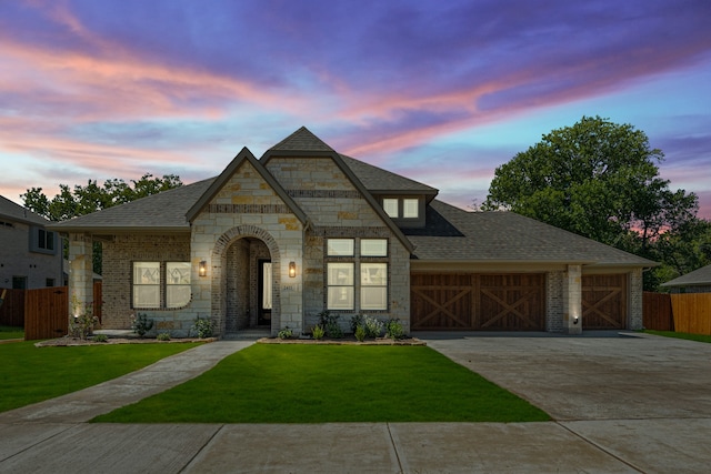 view of front of property featuring a garage and a yard