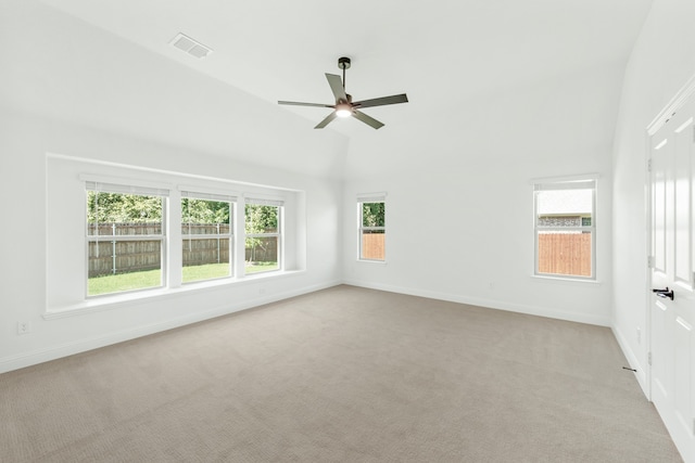 empty room featuring lofted ceiling, ceiling fan, and light colored carpet