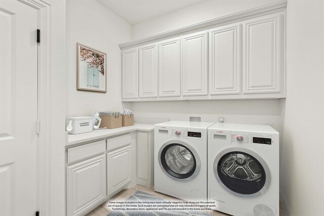 washroom featuring light tile patterned flooring, washer and dryer, and cabinets