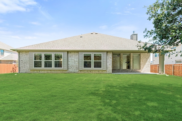 back of property with a yard and a patio area