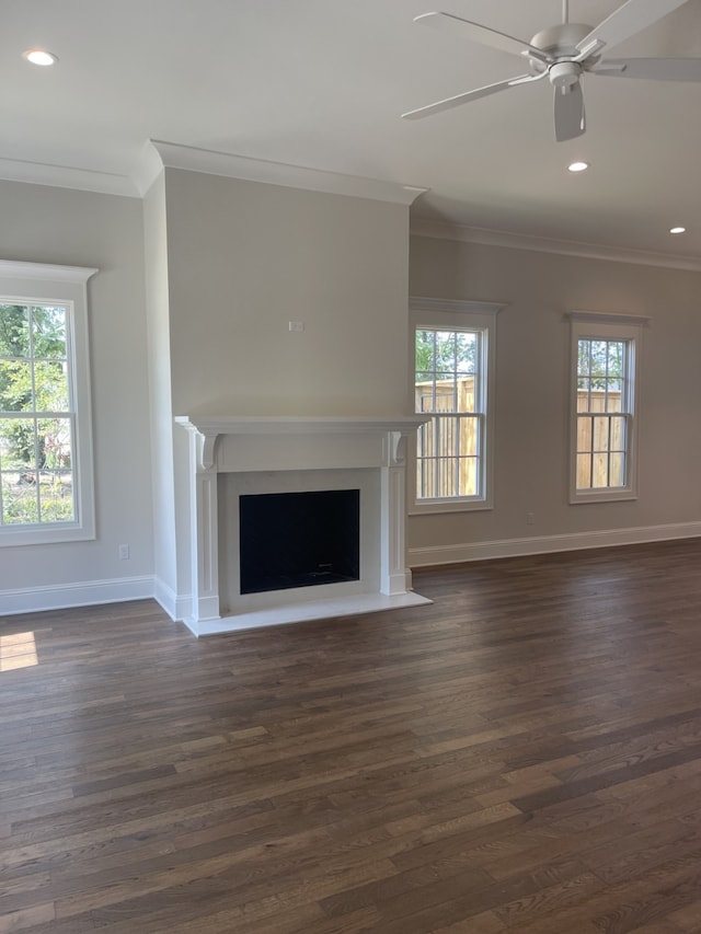 unfurnished living room with a fireplace with flush hearth, dark wood-style flooring, baseboards, and ornamental molding