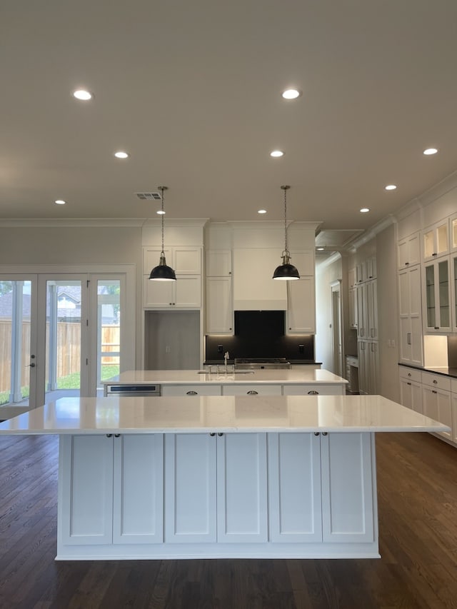 kitchen featuring white cabinetry, a large island, crown molding, and visible vents