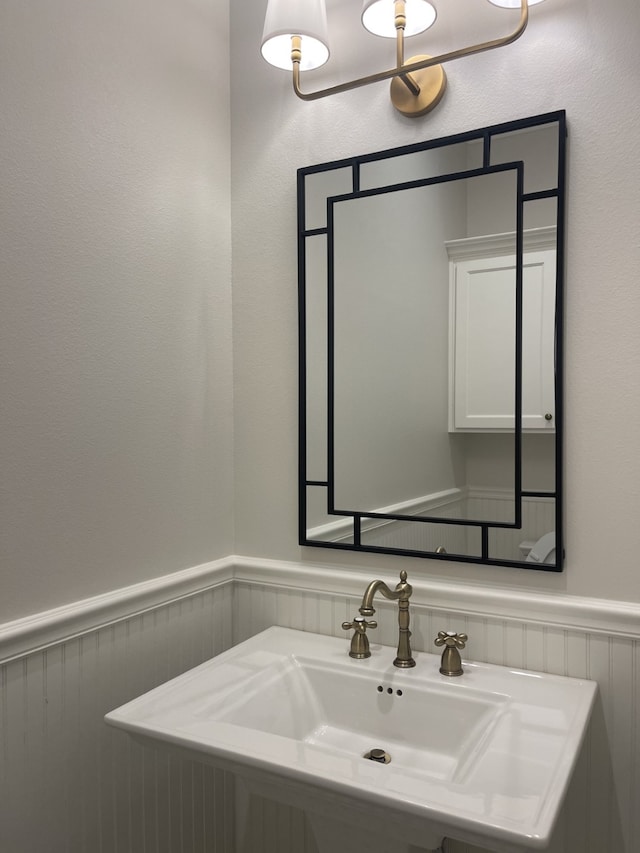 bathroom featuring a wainscoted wall and a sink