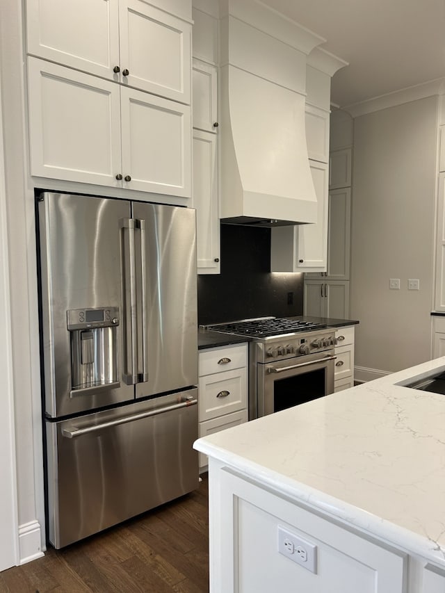 kitchen featuring dark wood-type flooring, white cabinets, high end appliances, and premium range hood