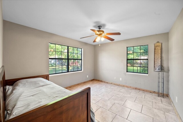 bedroom featuring ceiling fan and light tile floors