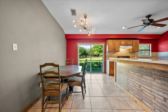 dining area with ceiling fan with notable chandelier and light tile floors