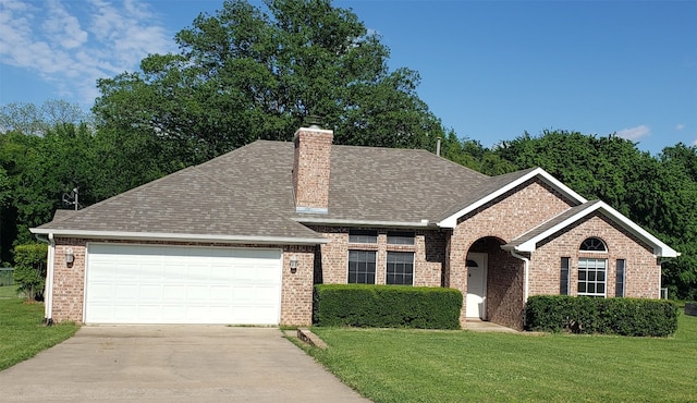 view of front of property with a front lawn and a garage