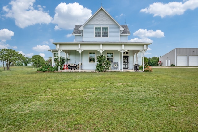 rear view of property featuring a lawn, a garage, and a porch