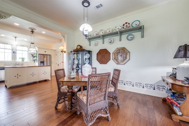 dining room featuring hardwood / wood-style flooring and ornamental molding