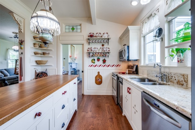 kitchen with sink, white cabinetry, dark wood-type flooring, hanging light fixtures, and stainless steel appliances