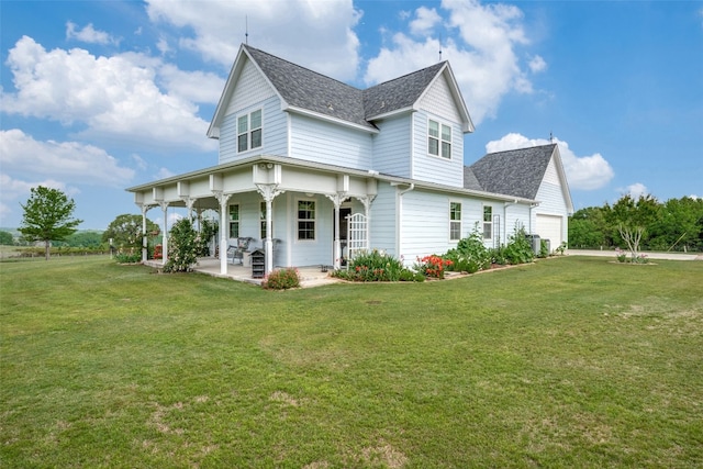 rear view of property featuring covered porch, a yard, and a garage