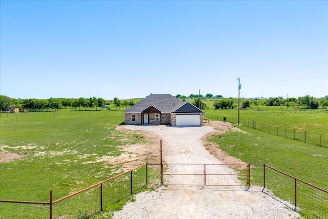 view of front of house with a rural view, a front yard, and a garage