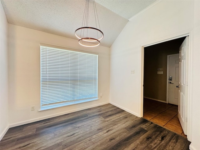 empty room with dark hardwood / wood-style flooring, a textured ceiling, and lofted ceiling