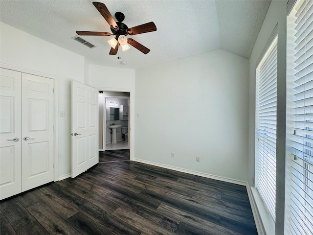 unfurnished bedroom with a textured ceiling, a closet, ceiling fan, and dark wood-type flooring