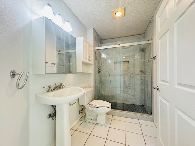 bathroom with tile flooring, walk in shower, toilet, and a textured ceiling