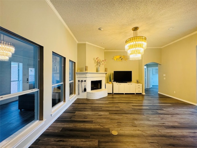 unfurnished living room with crown molding, dark wood-type flooring, a textured ceiling, and a fireplace