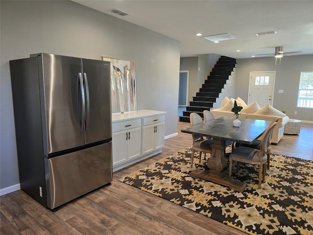 kitchen with hardwood / wood-style flooring, white cabinets, ceiling fan, and stainless steel fridge