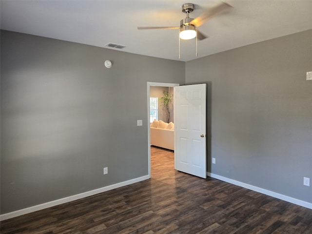 spare room featuring dark hardwood / wood-style flooring and ceiling fan