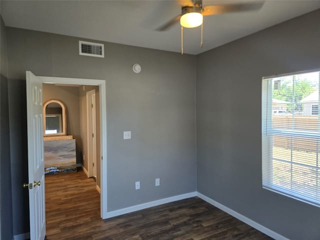 empty room with dark wood-type flooring and ceiling fan