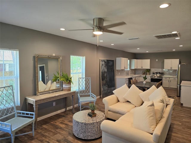 living room with plenty of natural light, dark hardwood / wood-style flooring, ceiling fan, and sink