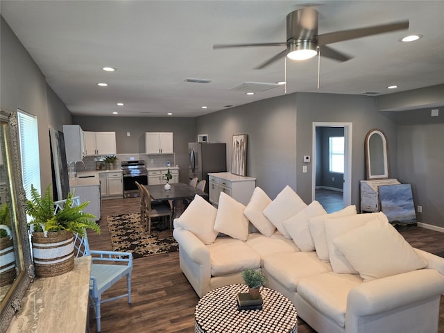 living room featuring ceiling fan, sink, and dark wood-type flooring