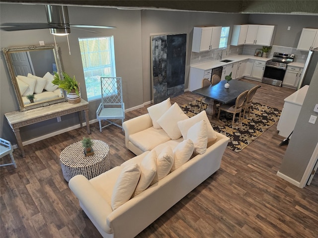 living room featuring dark hardwood / wood-style floors, sink, and ceiling fan