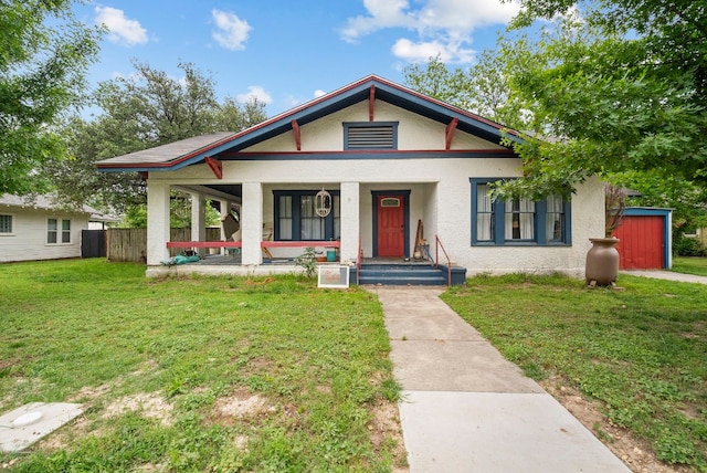 bungalow-style home with covered porch and a front yard