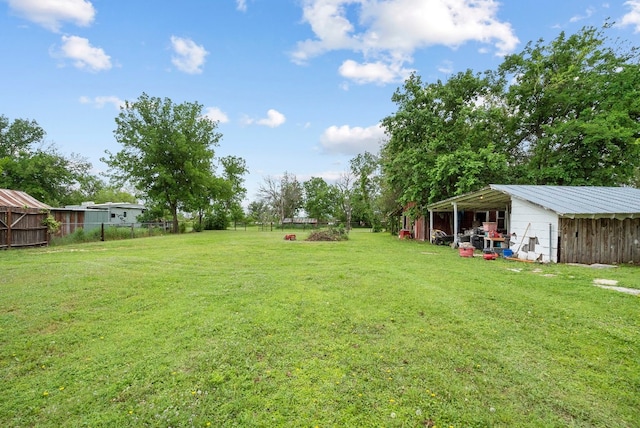 view of yard featuring a carport and an outdoor structure