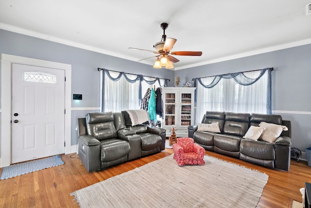 living room with crown molding, light hardwood / wood-style floors, and ceiling fan