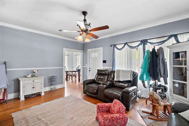 living room featuring crown molding, wood-type flooring, and ceiling fan