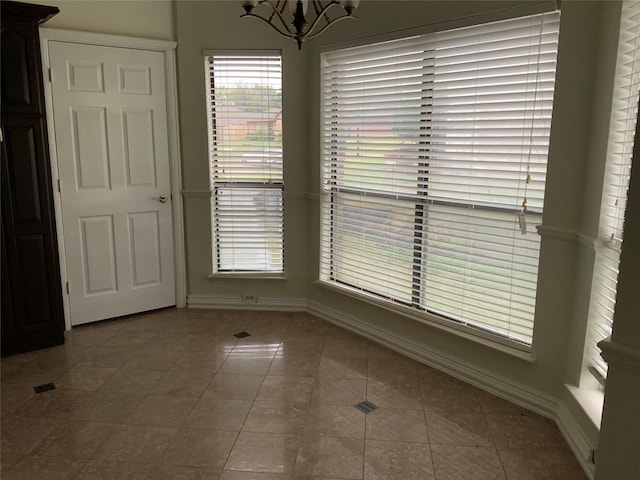 unfurnished dining area with tile patterned floors and a chandelier