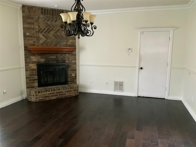 unfurnished living room featuring a fireplace, dark hardwood / wood-style flooring, ornamental molding, and a notable chandelier