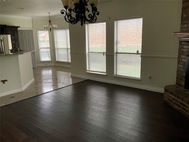 unfurnished dining area featuring hardwood / wood-style floors, a healthy amount of sunlight, and a brick fireplace