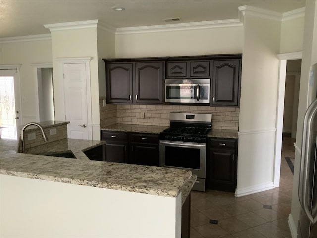 kitchen featuring stainless steel appliances, light stone counters, ornamental molding, and sink