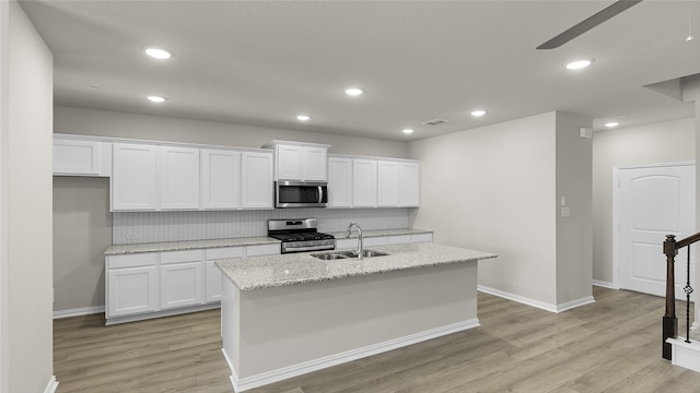 kitchen featuring sink, white cabinets, light hardwood / wood-style flooring, and stainless steel appliances