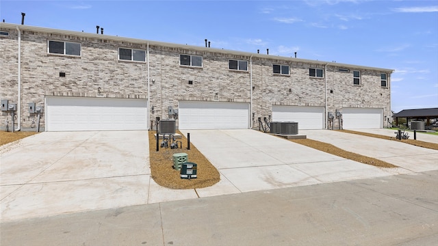 view of property featuring a garage and central AC