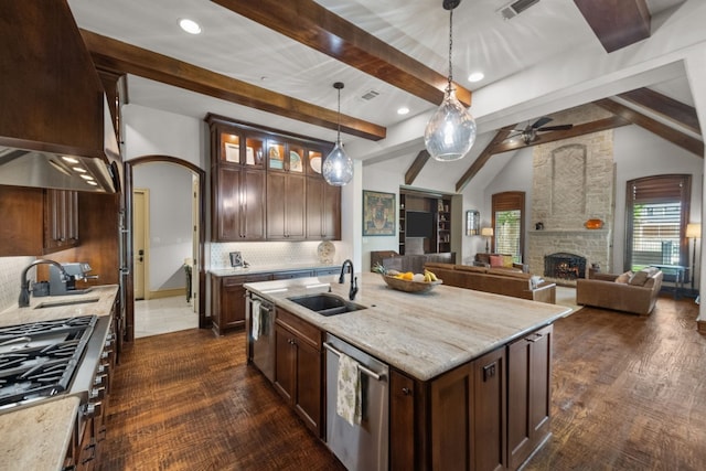 kitchen with a center island with sink, pendant lighting, sink, and tasteful backsplash