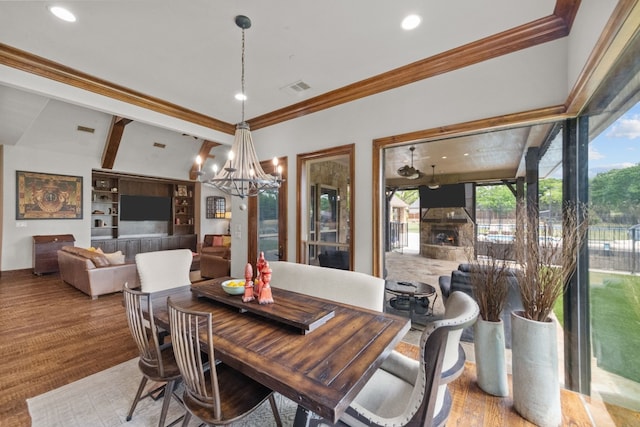 dining area with built in shelves, light hardwood / wood-style flooring, ornamental molding, and an inviting chandelier