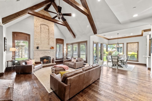 living room with a large fireplace, high vaulted ceiling, and a healthy amount of sunlight