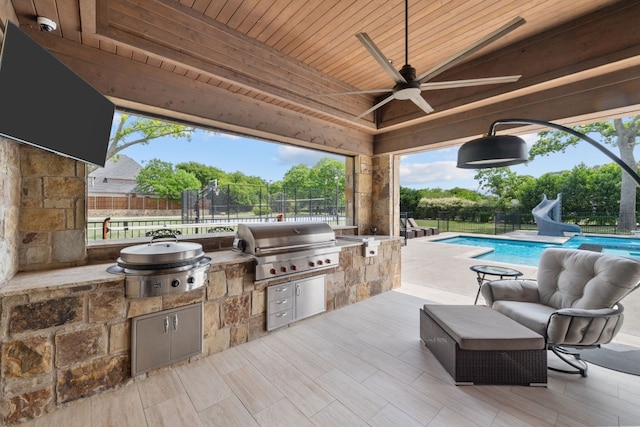 view of patio with a fenced in pool, ceiling fan, exterior kitchen, and a grill