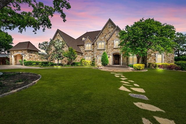 french country home featuring a lawn