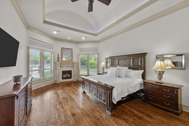 bedroom featuring multiple windows, dark hardwood / wood-style floors, vaulted ceiling, and ceiling fan