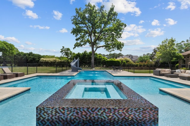 view of swimming pool featuring an in ground hot tub, an outdoor hangout area, and a water slide