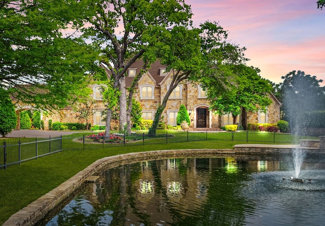 view of home's community with a yard and a water view