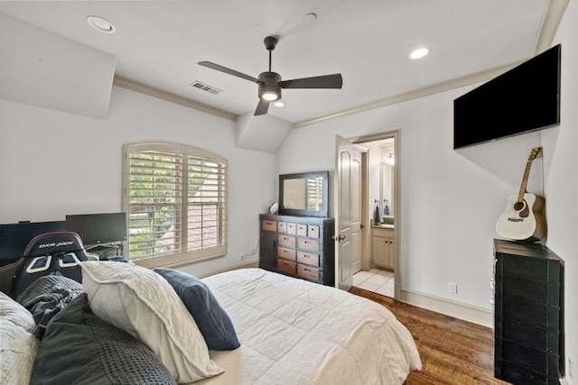 bedroom with ceiling fan, light hardwood / wood-style floors, ornamental molding, and ensuite bathroom