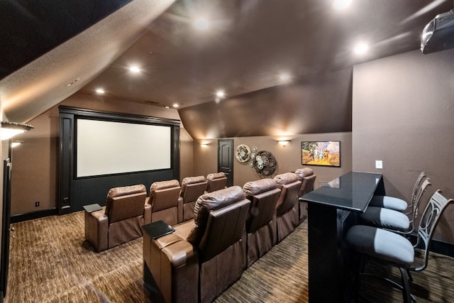 carpeted cinema room featuring vaulted ceiling