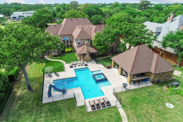 view of swimming pool featuring a lawn, a patio, and a water slide