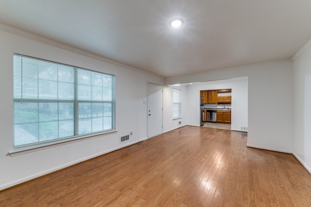 unfurnished living room with light hardwood / wood-style floors and ornamental molding